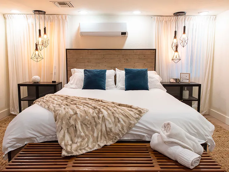 Master bedroom with its own heat pump for year-round temperature comfort and California King sized bed. The bedroom has a large walk-in closet and a television. The bedroom has its own private en-suite with jetted tub, shower, and sauna.
