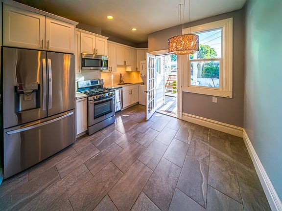 Modern Stainless Steel Kitchen with 3-door refrigerator, 5-burner gas stove, dishwasher, microwave, garbage disposal, washer and dryer. Under counter lighting and much more.