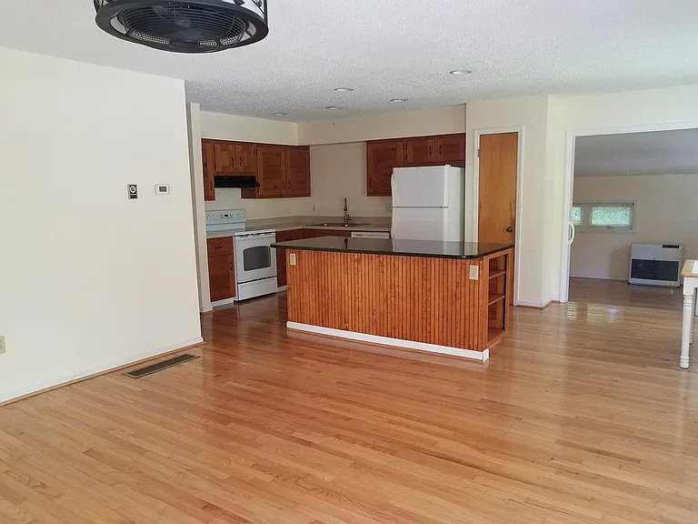 Open concept living, dining, kitchen area with Corian and granite countertops. Custom made cabinets.