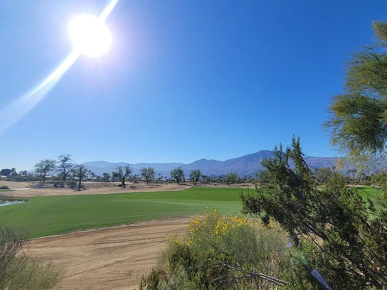 Green grass area on the backside of the pool, view of the golf course and beautiful mountains.
