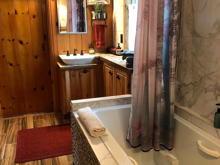 The tub is large and has Light therapy and AIr therapy and is a rain shower. and the floor has heat. the laundry room is the door you see in the back.
