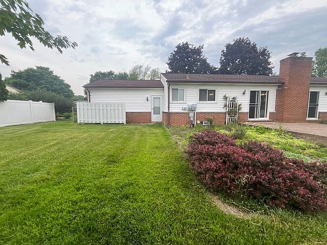 Spacious back yard with brick paving patio and a shed