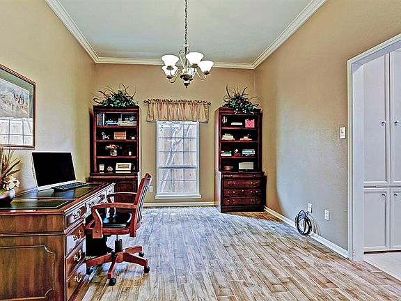 This is the Formal Dining Room located off the kitchen. Currently being used as an office. This wood look tile flooring was installed in 2018. If you choose to use this as a dining room there is plenty of space for a long table and china cabinet.