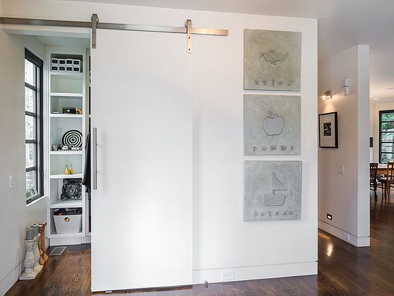 Sleek barn doors opens to large multi purpose closet/mud room