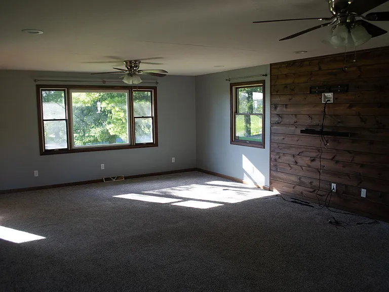 Living room with walk-out deck access and entertainment wall.