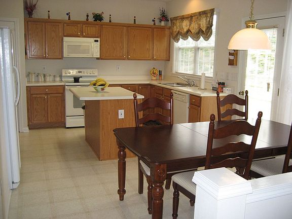 Gourme Kitche overlooks FR and features stained cabinets, island, 