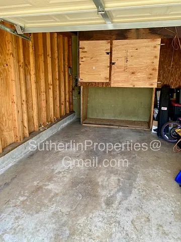 Interior of garage with storage locker. The left side of garage is assigned to Apt C, the right side of the garage is assigned to Apt B.