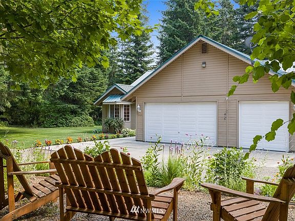 3 car garage with ample room highlighted as you drive onto the property.  Sitting areas like this one, with the Adirondack chairs, are situated so the yard can be appreciated and enjoyed.