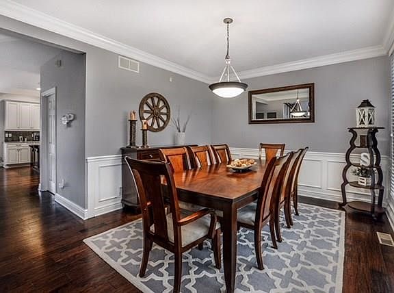 Formal dining room is detailed with wainscoting and crown molding.