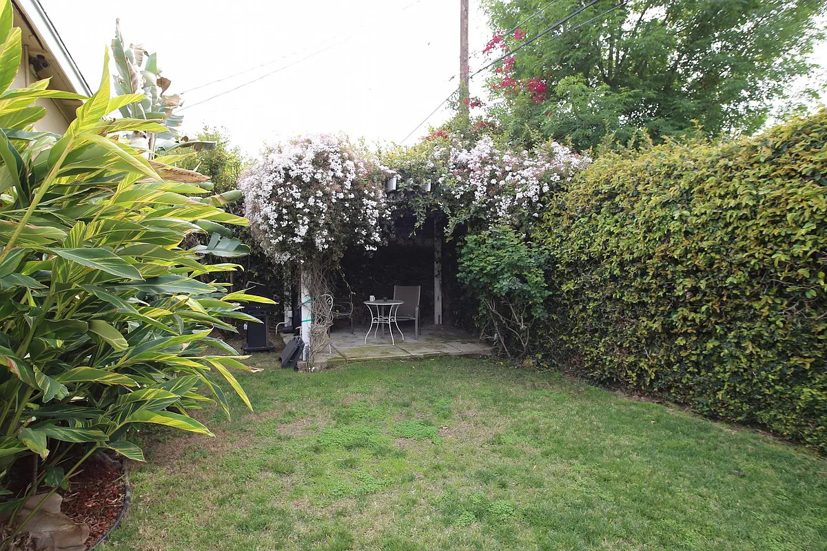 This photo illustrates about half of the backyard with a patio and covered pergola. 2nd patio not shown. - 6521 Baird Ave