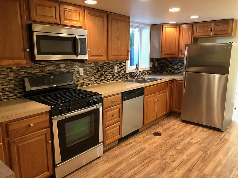 Open kitchen with gas stove, dishwasher and storage