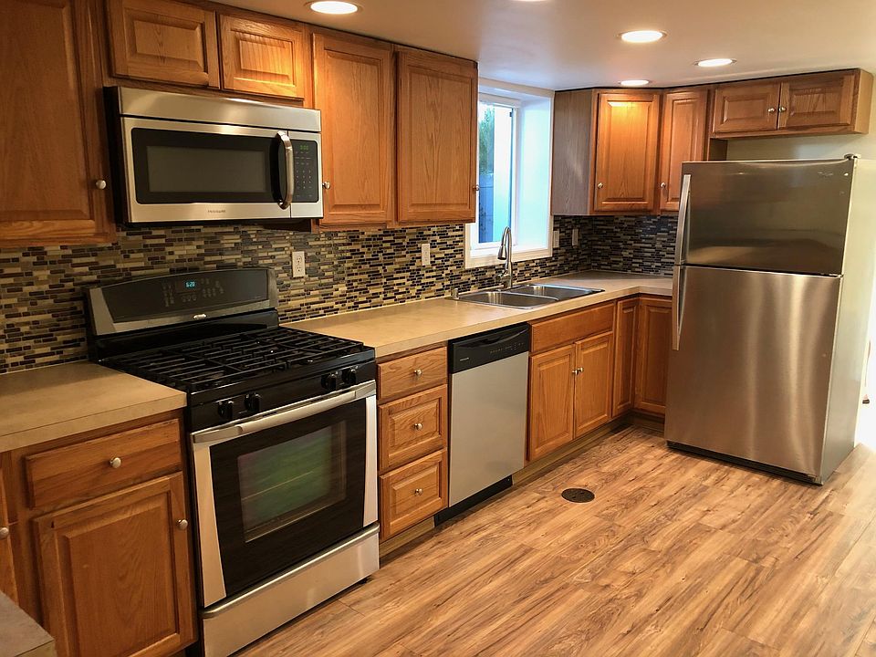 Open kitchen with gas stove, dishwasher and storage
