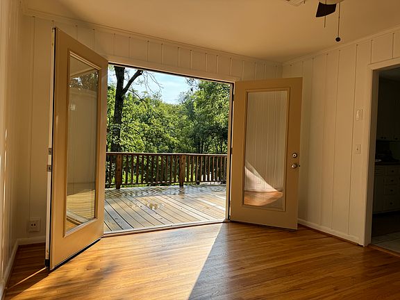 Dining room with french doors leading to large deck. Afternoon light fills this room