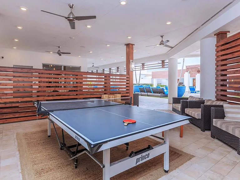 Enjoy a fun-filled game lounge that blends indoor comfort and outdoor vibes, featuring ping pong, pool, and plenty of space to play.