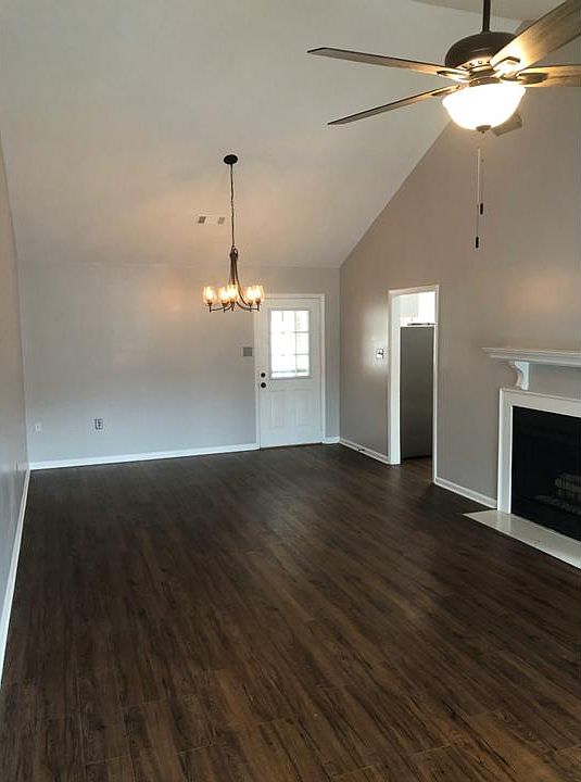 Great room with luxury vinyl plank flooring, new light fixtures, fireplace, and entry backyard.