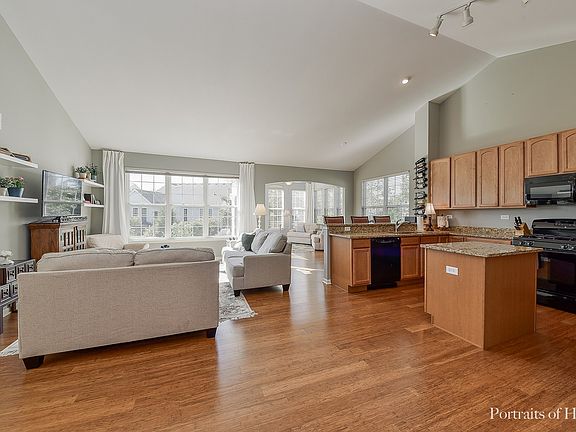 Open Floor Plan with Vaulted Ceiling, plenty of Windows bringing in natural light, Wood Laminate Flooring throughout.