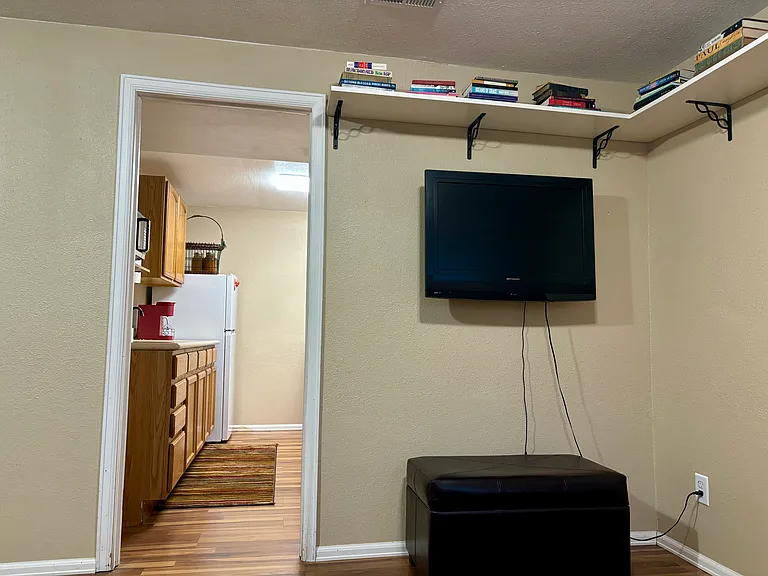 Livingroom: 32" LED television for use with tenant's streaming services (or extra monitor for work), bookshelf, entry to kitchen