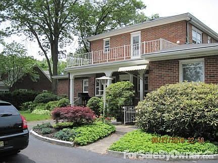 Rear view of house
						:
						Beautiful landscaped yard with rear porch and balcony on upper level.