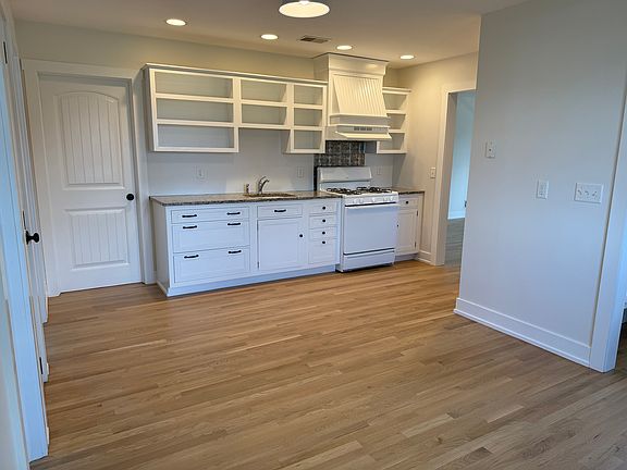 Kitchen with granite counter and pantry closet.