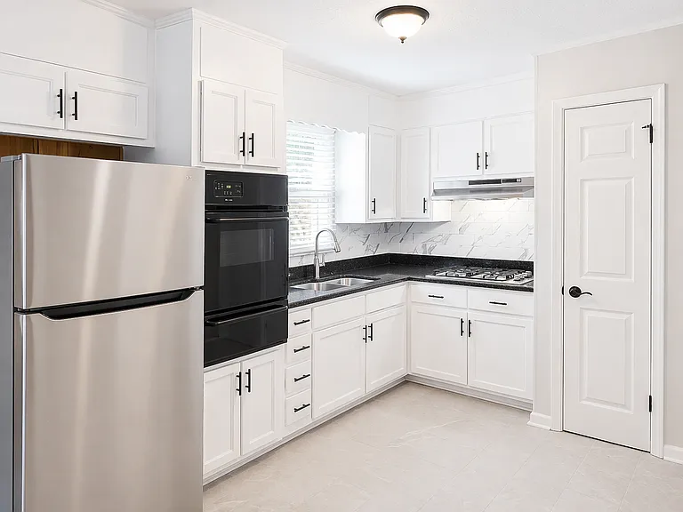 Newly renovated kitchen with new granite countertops, new stainless steal stove and refrigerator and white cabinets.