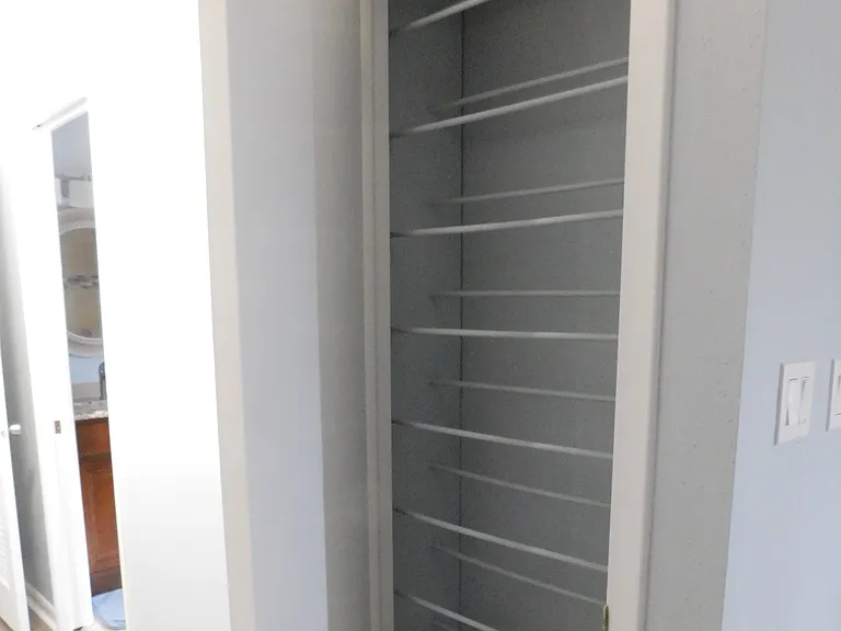 The southwest closet contains hanging rods. Just beyond the closet you can see the entrance to the master bath.