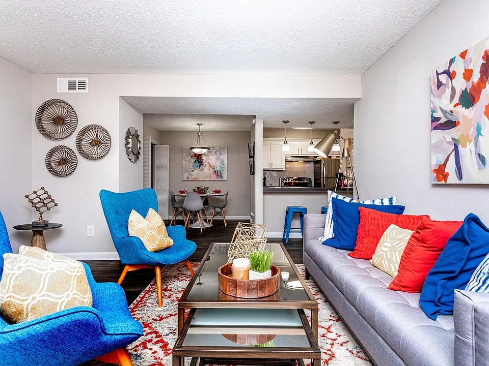 Bright open-concept living room with modern furnishings and gray sofa.
