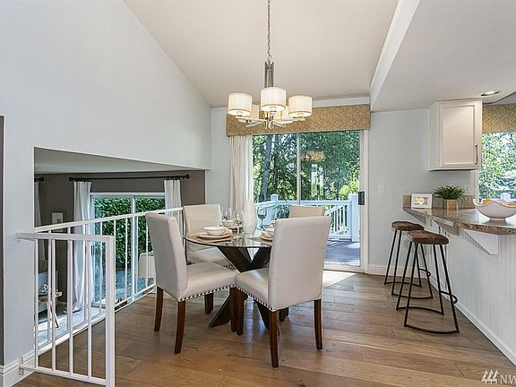 Dining room off the kitchen with view of family room downstairs and access to the large deck.
