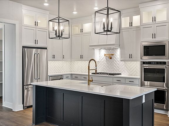 The kitchen of the Texoma has white wood cabinetry and a tile backsplash.