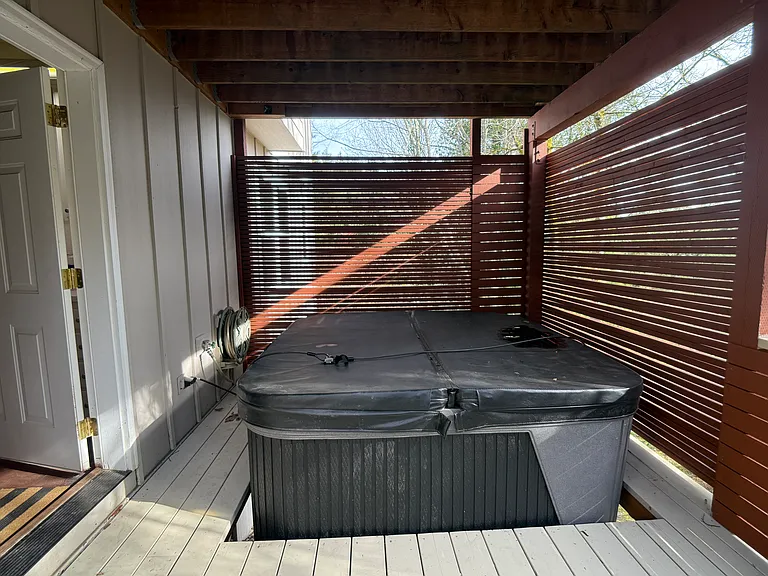 Semi-private, covered outdoor hot tub area designed for year-round relaxation.