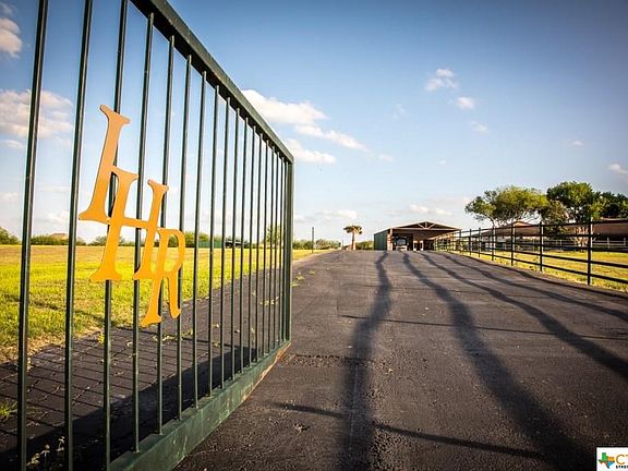 GATED ENTRANCE WITH WIDE PAVED DRIVE AND PARKING AREAS