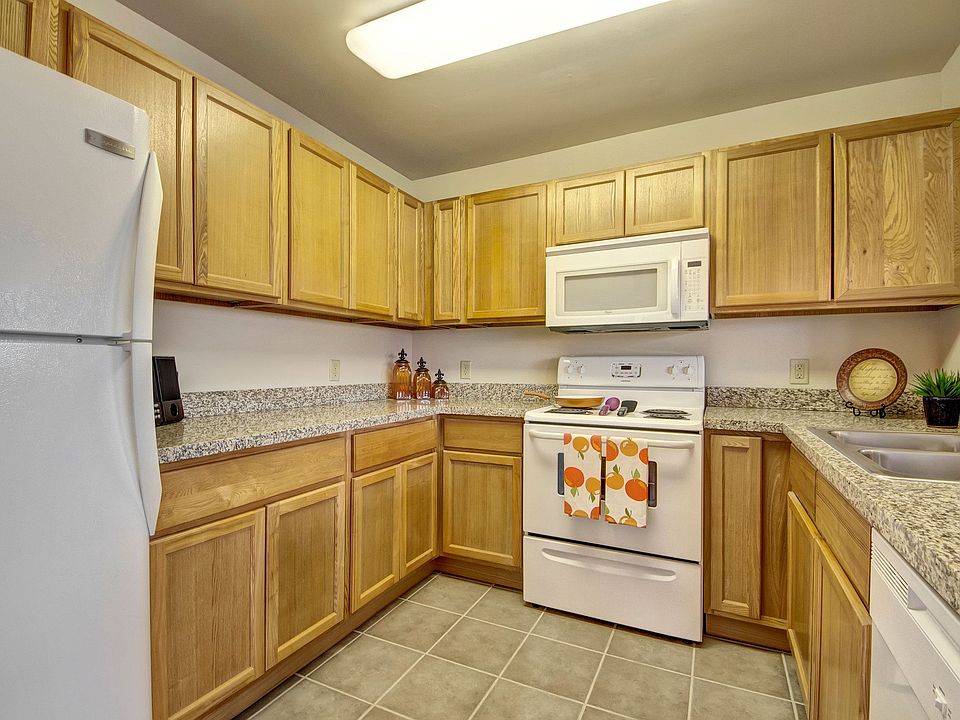 A kitchen with lots of cabinet storage, double sinks, and granite countertops