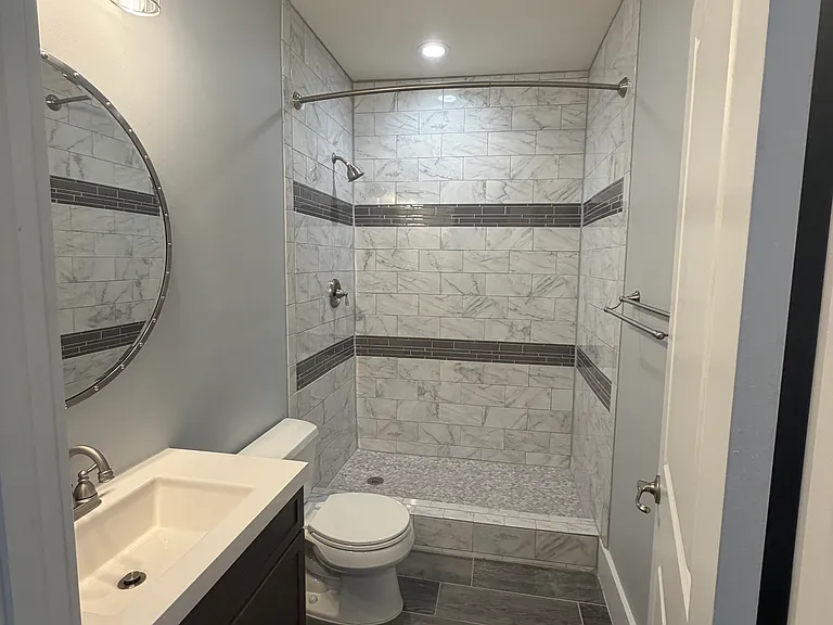 Beautifully remodeled basement full bath with a modern walk-in shower.