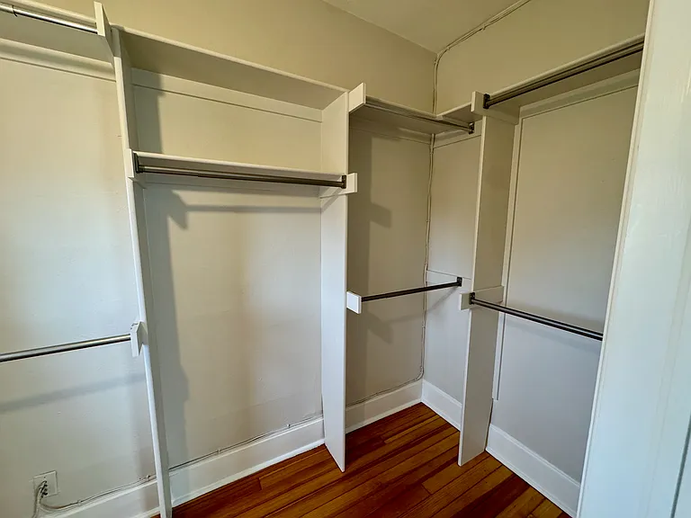 Primary bedroom walk in closet including original leaded glass oval window (see next photo)