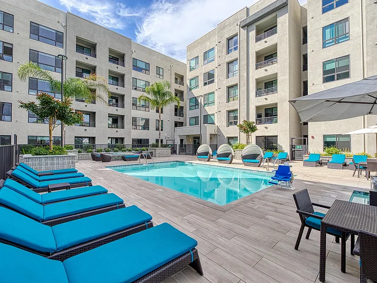 Open pool area with vibrant loungers, shaded spots, and nearby outdoor kitchens for easy enjoyment.
