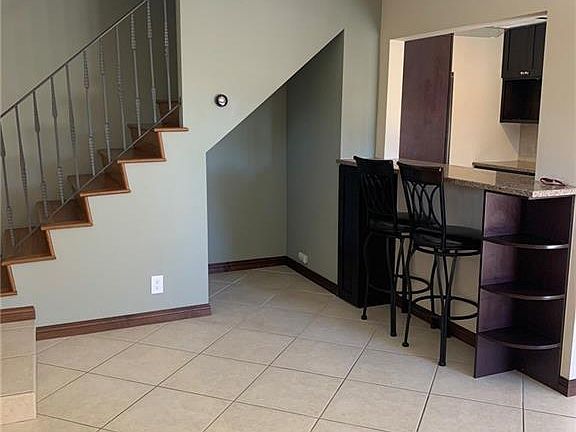 Walls are all painted white now has storage under stairs for a beverage fridge or a small cabinet.