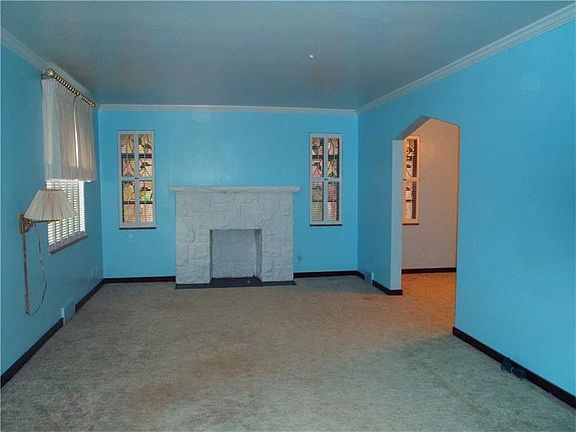 LIVING ROOM WITH DECORATIVE FIREPLACE AND STAINED GLASS WINDOWS