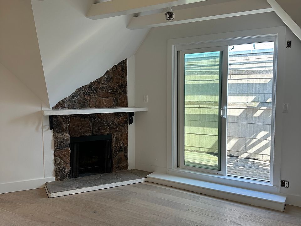 Living/dining area w/hardwood floors, wood burning fireplace and doors to private outdoor space.