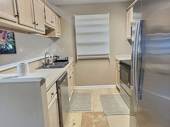 Kitchen with stainless steel fridge, stove, dishwasher and microwave.