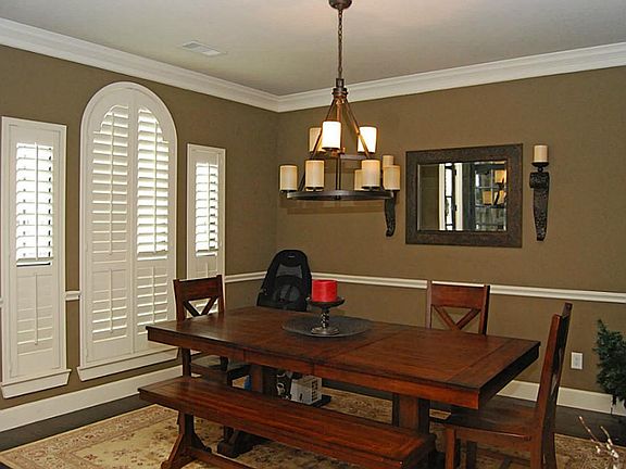 Designer paint, an accent chair rail and crown molding adorn the walls of the Dining Room and comple