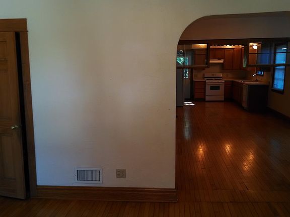 living room view thru dining room to kitchen. Door on left is bathroom