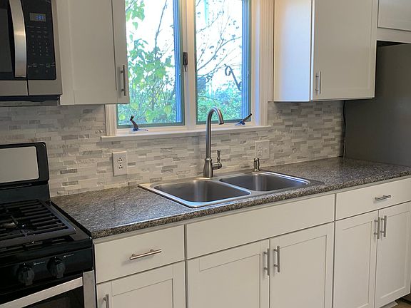 Brand new white cabinets, granite countertops, new backsplash, and stainless appliances
