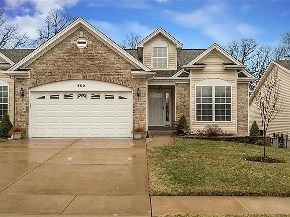 Brick and Vinyl Elevation offering great curb appeal from the windows in the garage door, dormer, box window in the 2nd main level bedroom, nice landscaping wall, to the oversize garage and extended driveway ready for you to enjoy!
