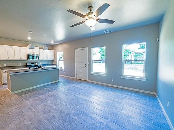 Clean and modern open great room, with wood look ceramic tile and beautiful quartz counter tops