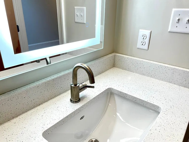 Sink/mirror detail with sparkly quartz countertop.