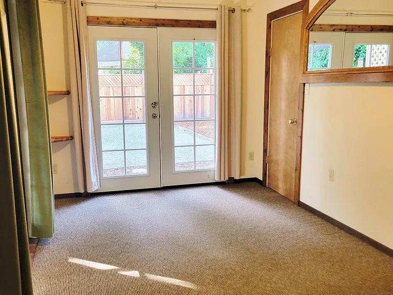 Secondary room that leads to fenced in yard and screened in porch