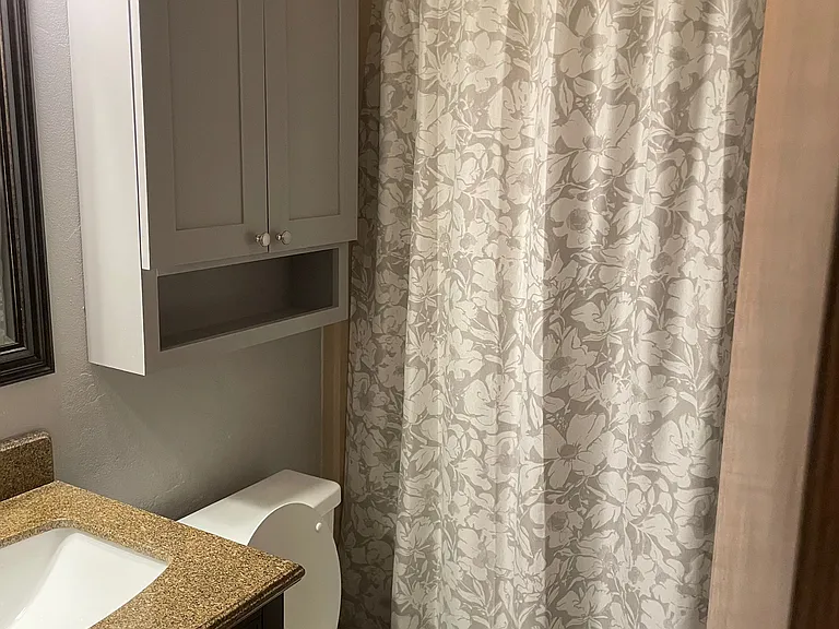Hall bath is neutral colors.