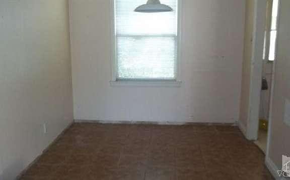 Dining room with tile floor, needs paint & baseboards.
