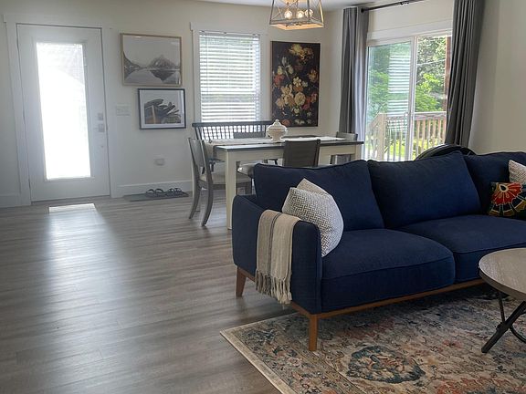 View from bottom of the stairs looking at entry way, living room and dining area
