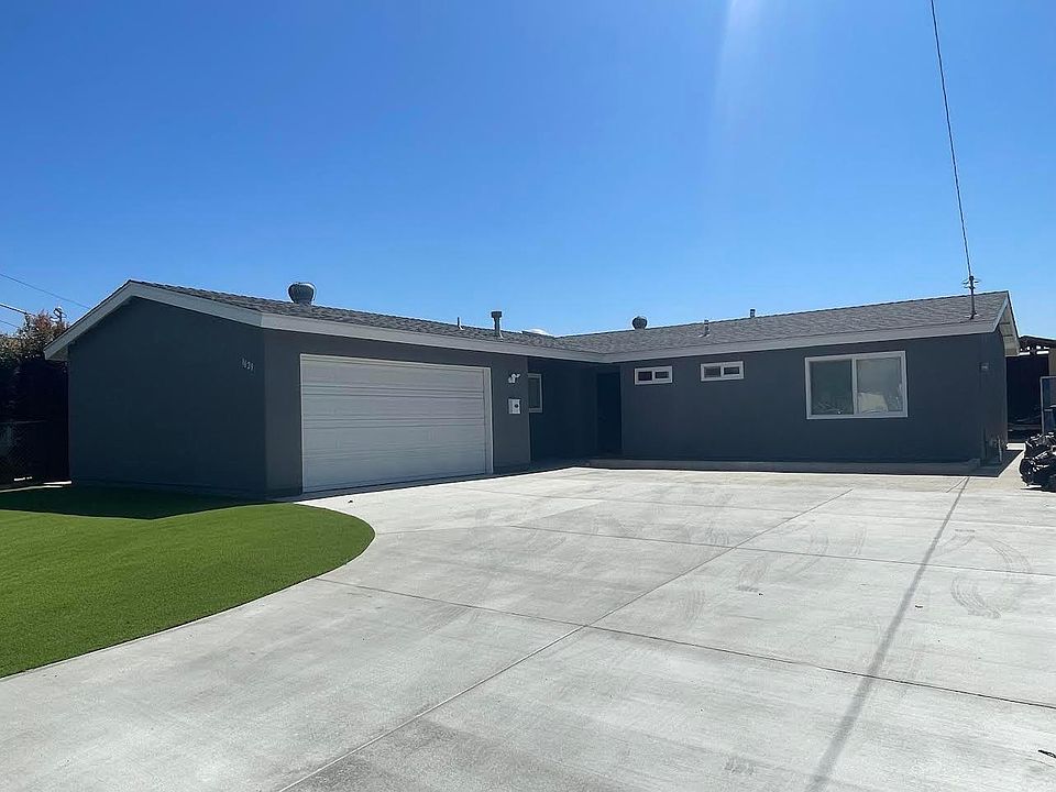 Front view of house has new cement slab and new turf grass. New roof and new paint on outside of home