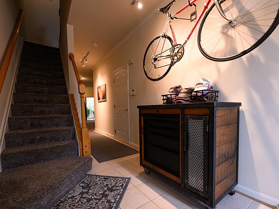 Entryway with hallway to finished lower level. Stairway to main living area on left; door to garage on right.